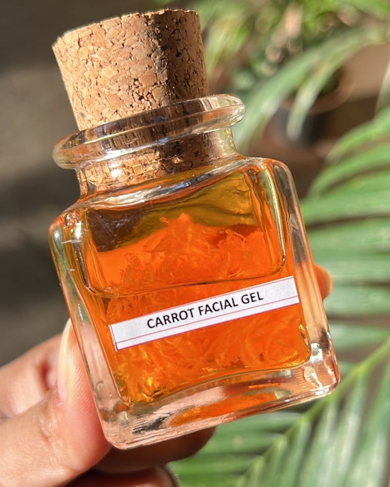 A small clear glass jar with a cork lid, labeled 'Carrot Facial Gel', held in hand with a blurred green background.