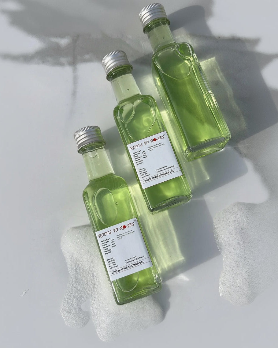 Three green glass bottles with metal caps on a light gray background