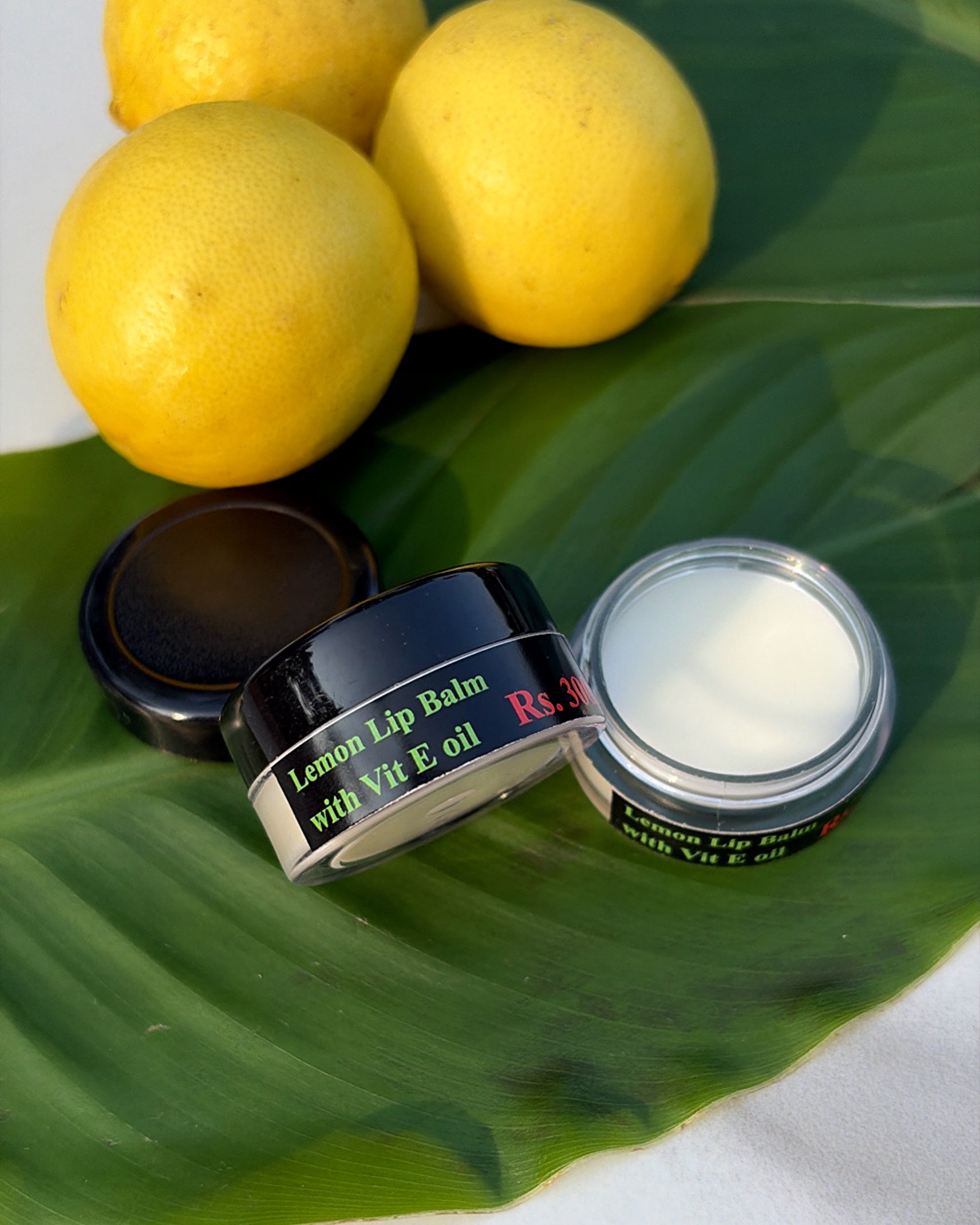 Lip balm container with lemon on a green leaf