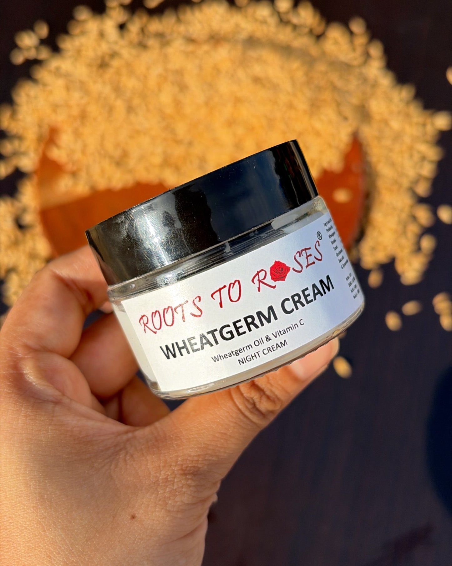 Jar of Wheat Germ Cream held by a hand with scattered wheat germ in the background